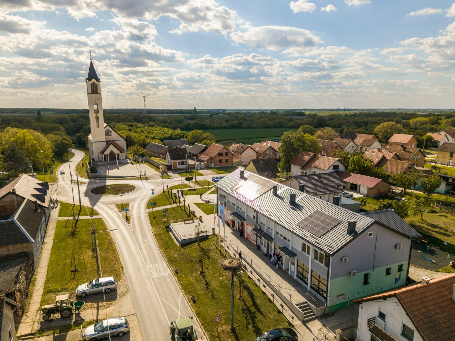 Pogled iz zraka na središte Bogdanovaca — crkva, kružni tok i zgrada Općine