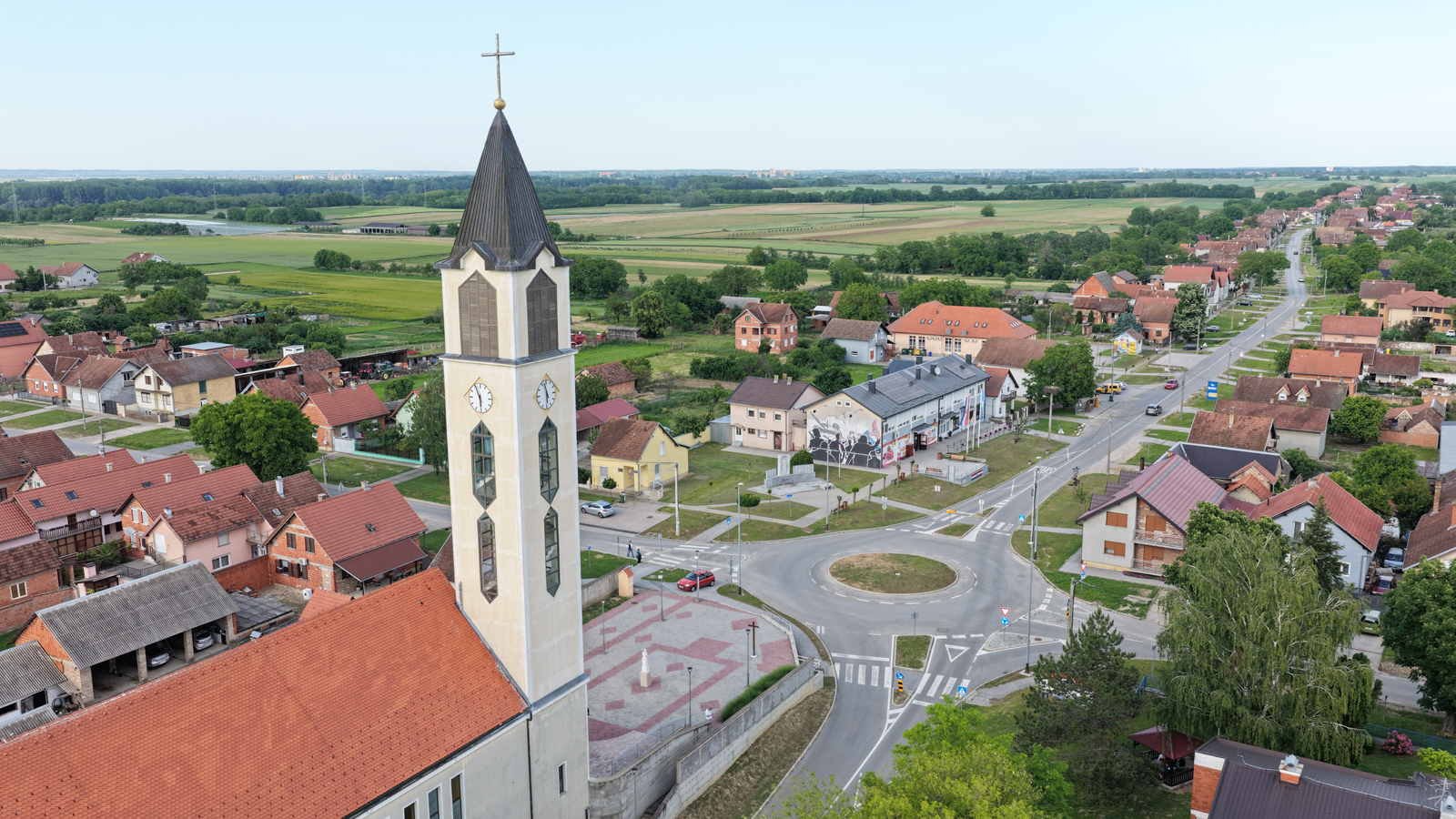 Zvonik crkve i kružni tok u središtu Bogdanovaca iz zraka
